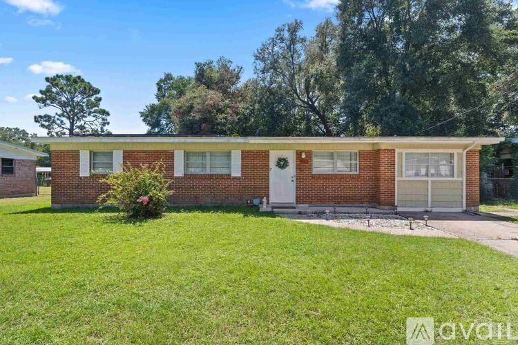 A red brick house with a green lawn in front.