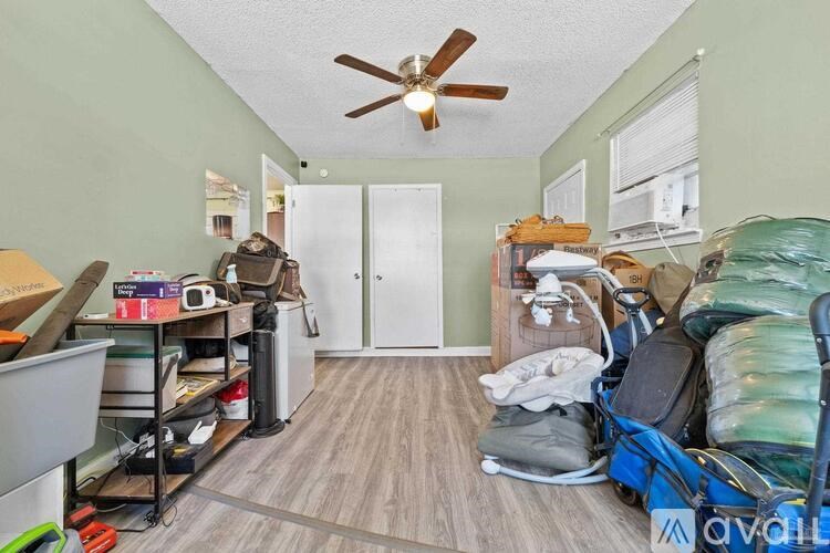 A room with a ceiling fan and a door is shown.