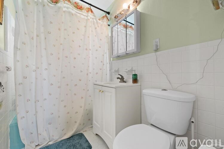 A white toilet sits next to a white sink in a bathroom.