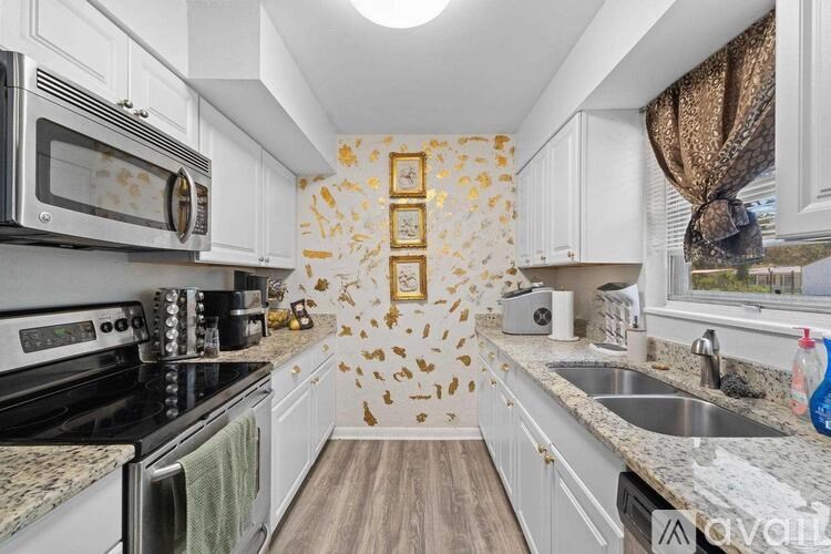 A kitchen with white cabinets and a black stove top oven.