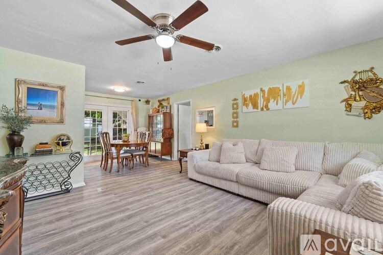 A living room with a white couch and a ceiling fan.