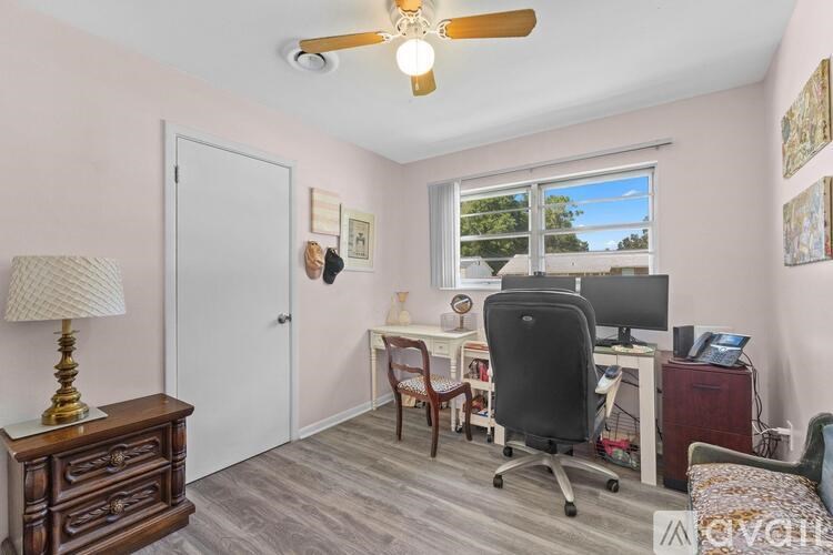 A room with a desk, chair, and a lamp.