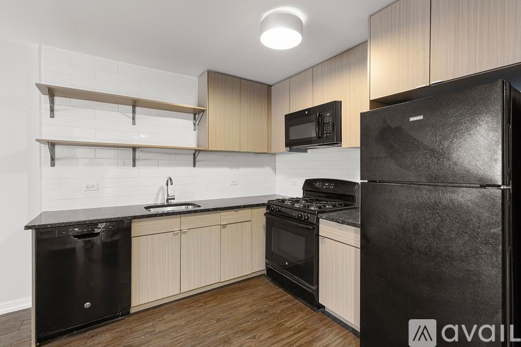 A kitchen with black appliances and wooden cabinets.