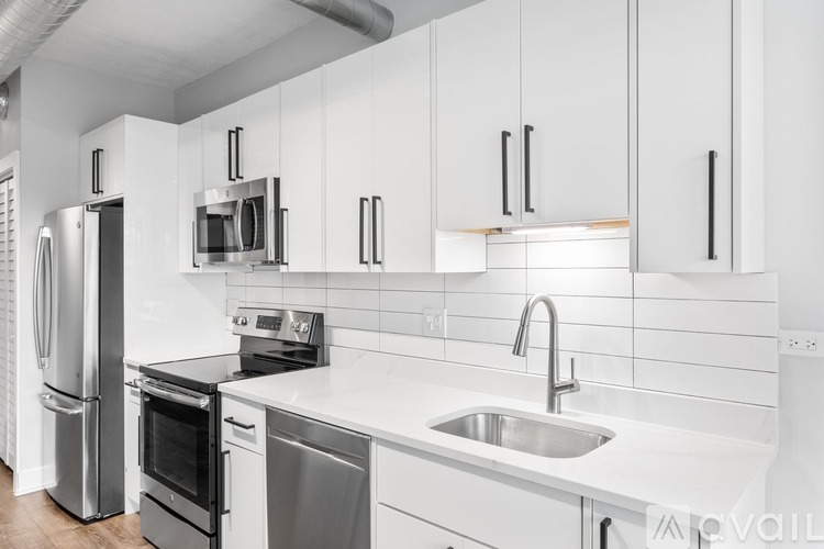 A modern kitchen with white cabinets and stainless steel appliances.