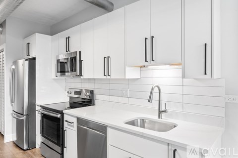 A modern kitchen with white cabinets and stainless steel appliances.