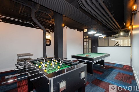 A pool table with a green felt cloth and white balls is in the foreground of the image.
