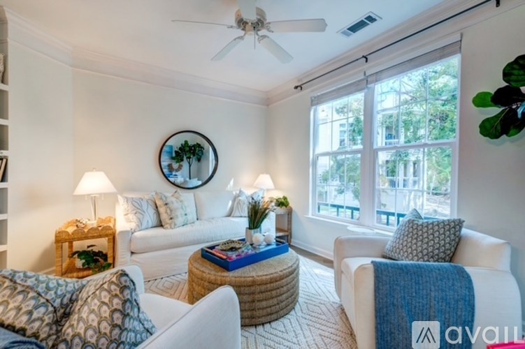 A room with wooden flooring and a window with sunlight coming through.