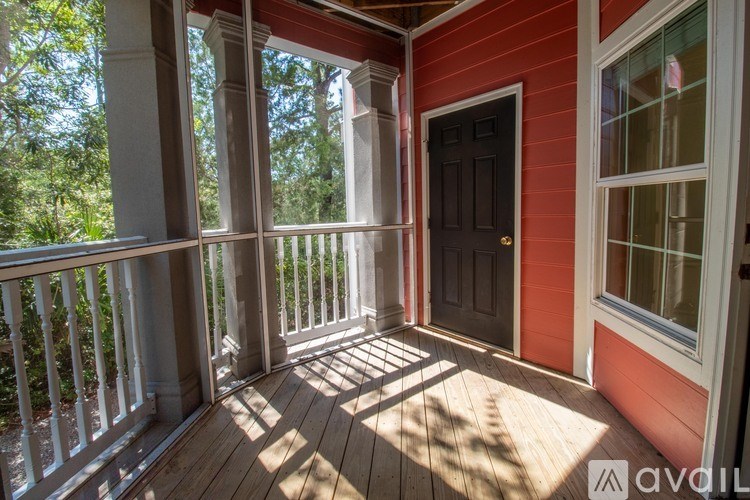 A porch with a red wall and a black door.