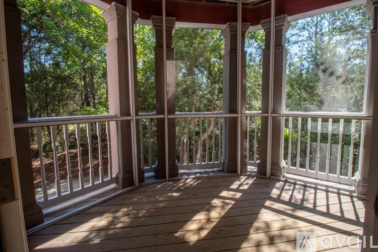 A porch with white railings and pillars.