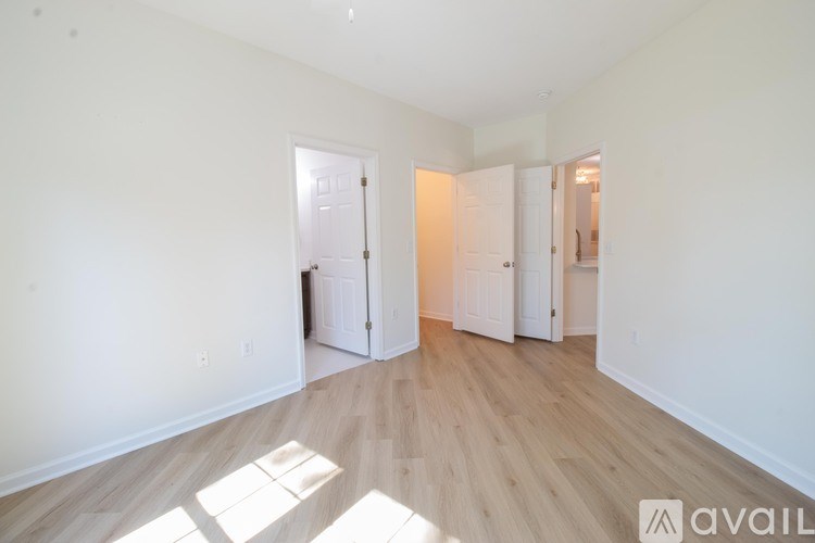 A large empty room with wooden floors and white walls.
