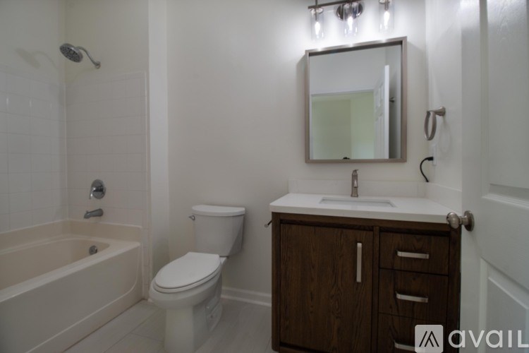 A bathroom with a white toilet, sink, and bathtub.