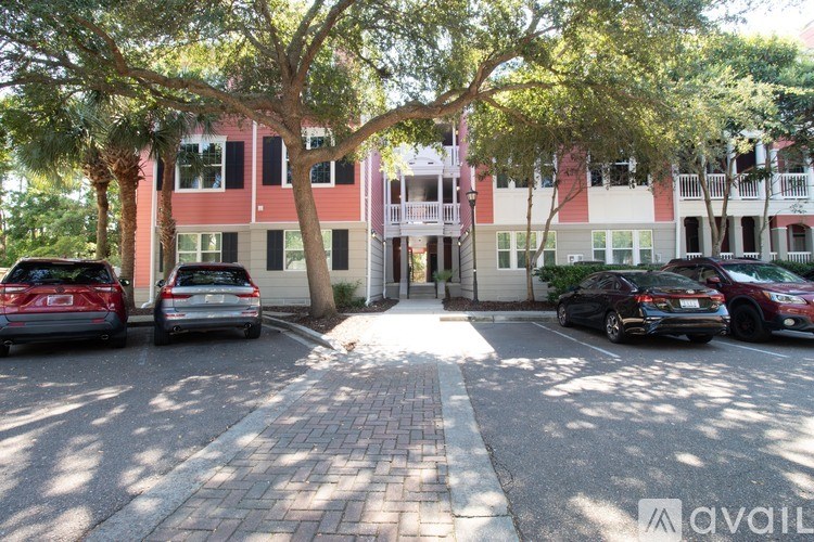 A parking lot with cars and a building in the background.