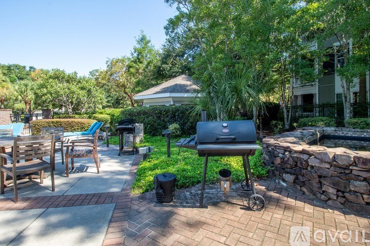 A backyard with a grill and a stone wall.