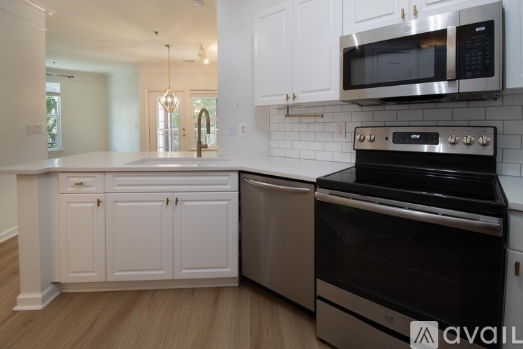 A kitchen with white cabinets and a black stove top oven.
