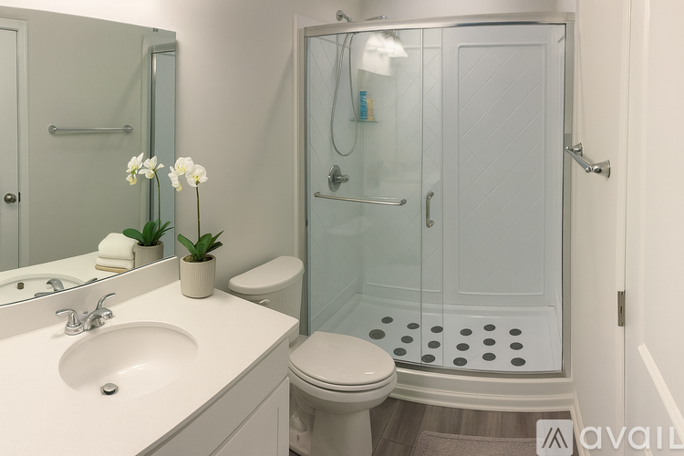 A bathroom with a toilet, sink, and shower.