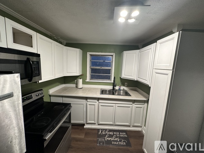 A kitchen with white cabinets and a black stove top oven.