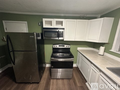 A kitchen with a refrigerator, oven, and microwave.