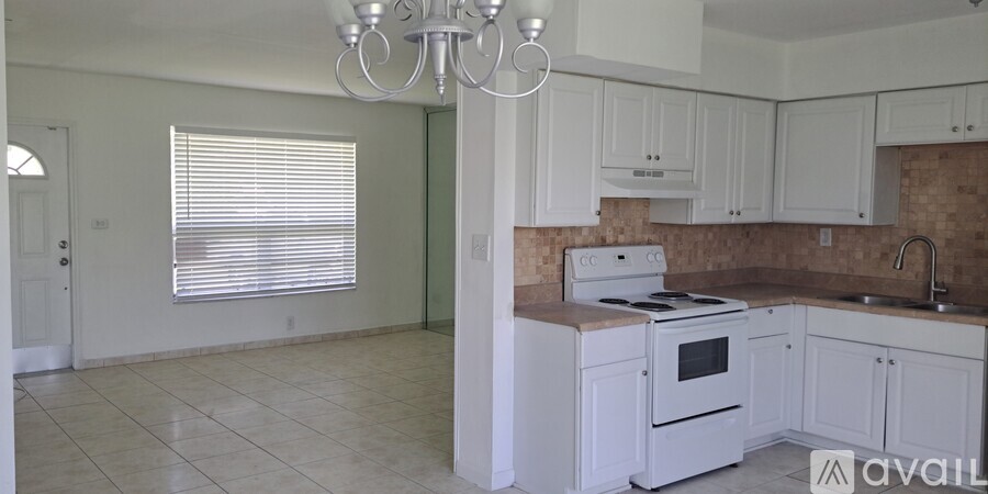 A kitchen with white cabinets and a tiled floor.