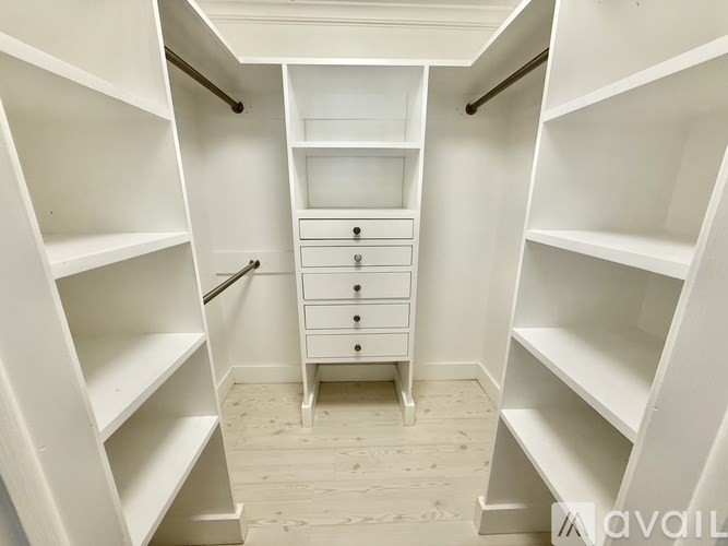 A white walk-in closet with shelves and drawers.