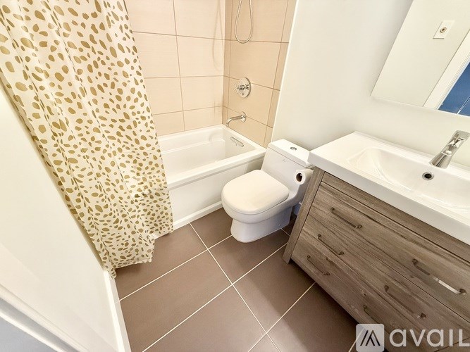 A bathroom with a leopard print shower curtain.