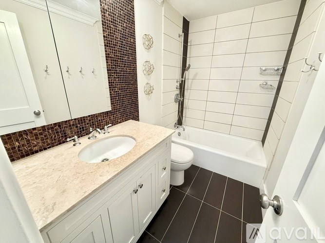 A bathroom with a sink, toilet, and bathtub.