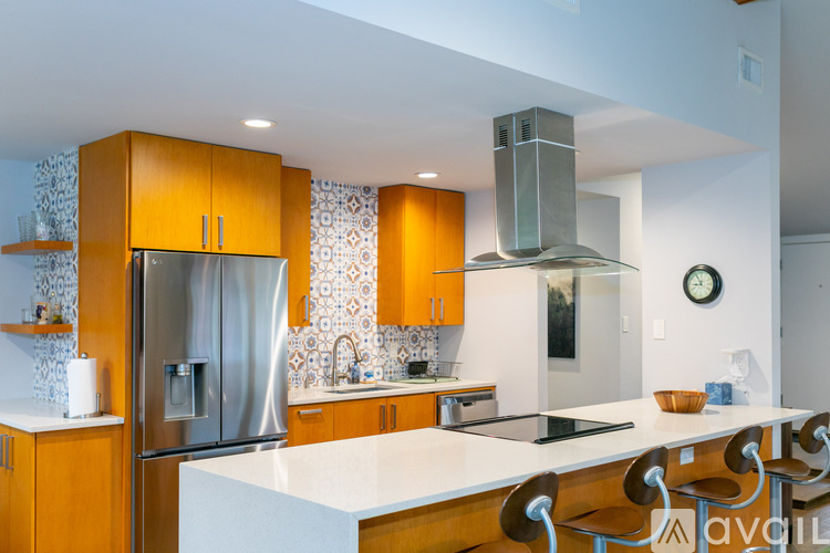 A kitchen with wooden cabinets and a stainless steel refrigerator.