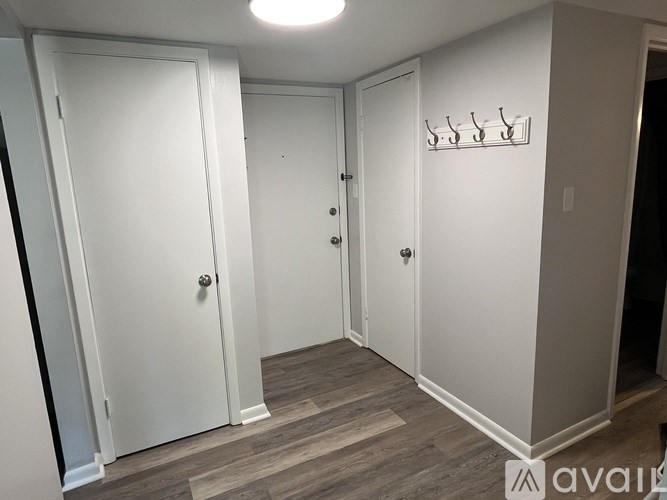 A hallway with two doors and a coat rack.