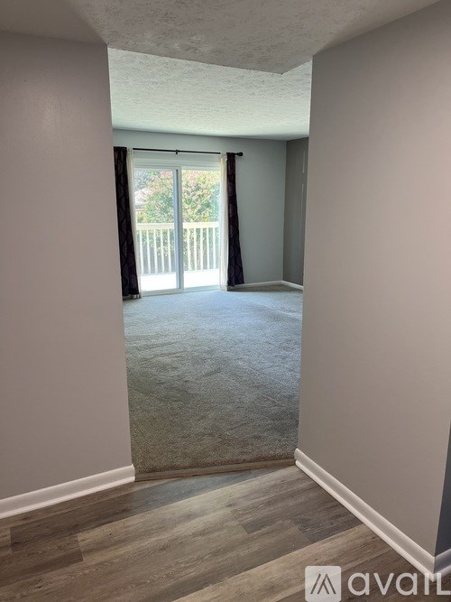 A room with a sliding glass door leading to a balcony.