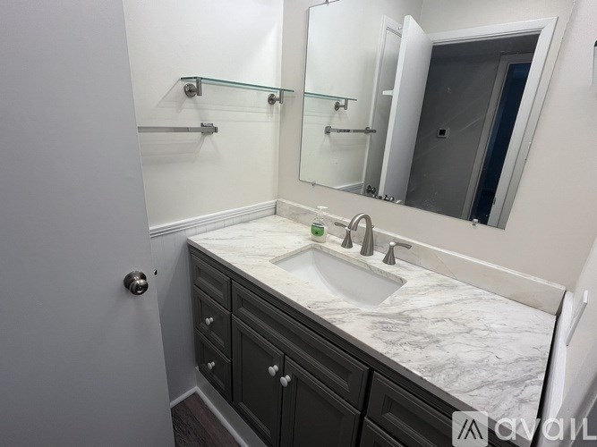 A bathroom with a marble countertop and a large mirror.