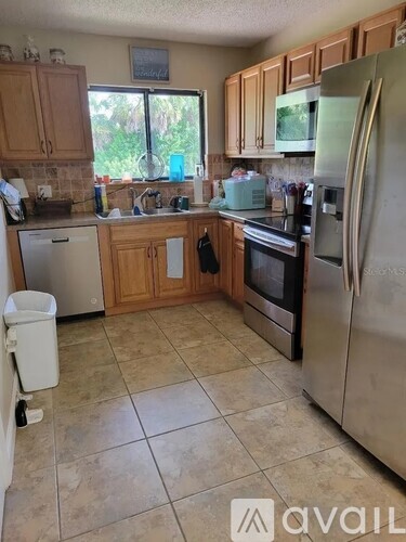A kitchen with tile flooring and a refrigerator.