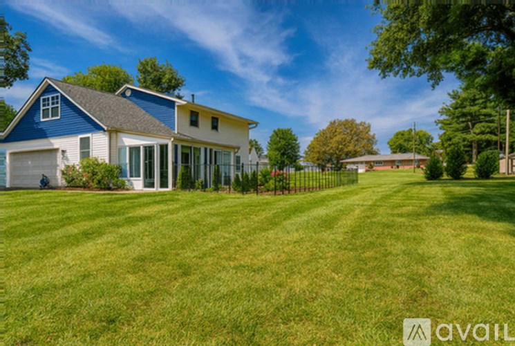 A blue house with a white fence in front of it.