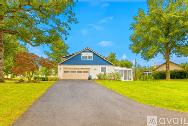A house with a blue roof and a driveway in front.