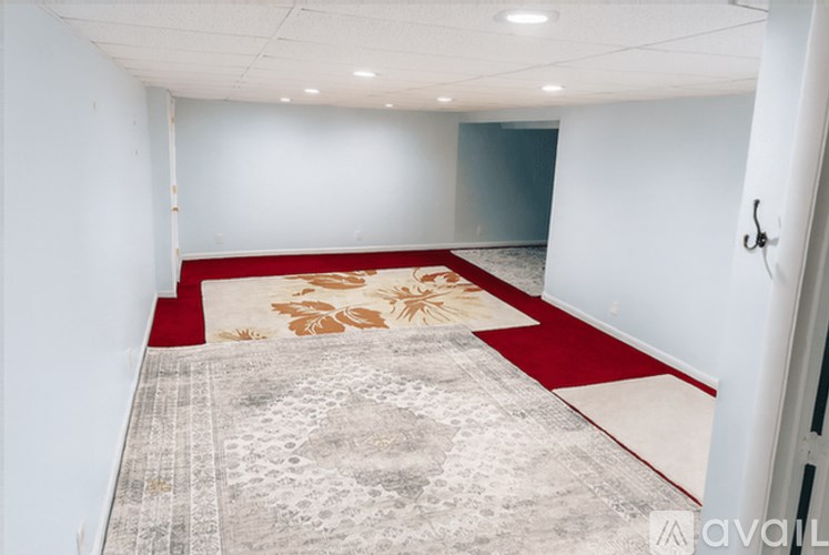 A room with a red carpet and a grey carpet with a floral design.