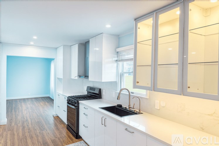 A kitchen with white cabinets and a black stove top oven.