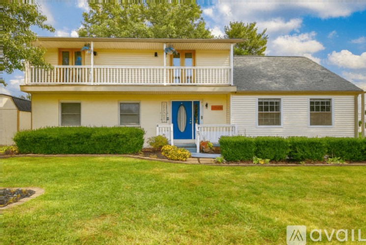 A two-story house with a blue door and a balcony.