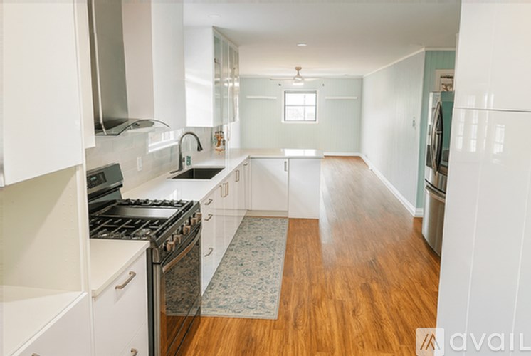 A kitchen with white cabinets and a black stove top oven.