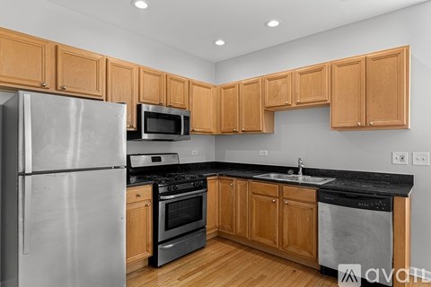 A kitchen with wooden cabinets and a stainless steel refrigerator.