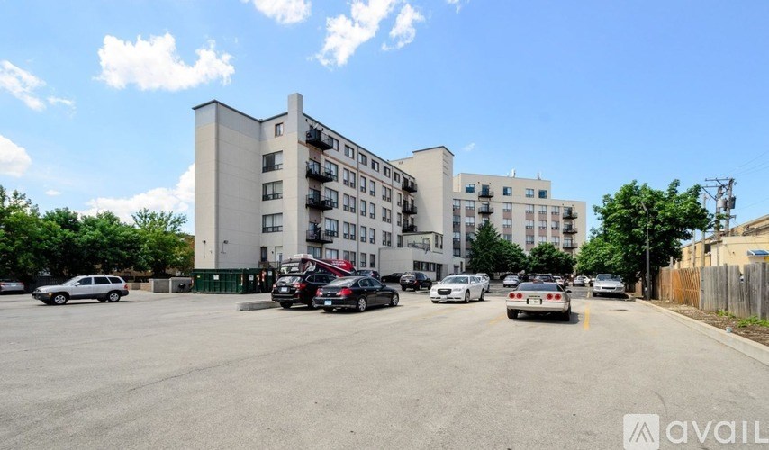 A parking lot with cars and apartment buildings in the background.