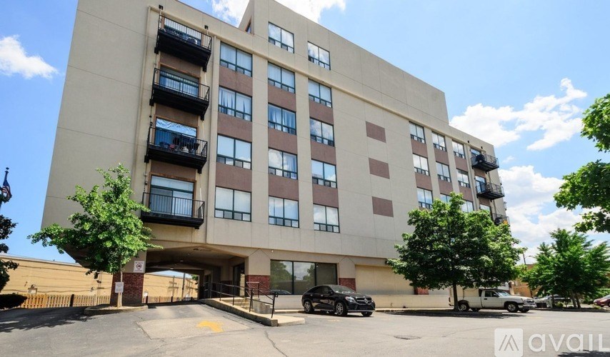 A large apartment building with a parking lot in front.