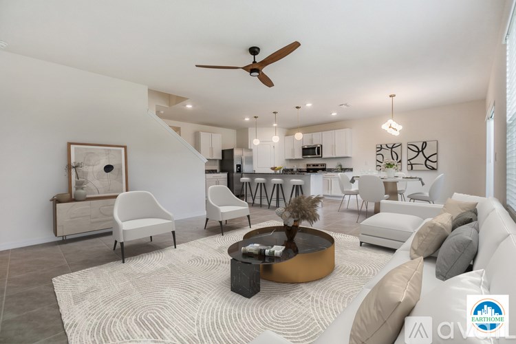 A living room with a white couch, a coffee table, and a ceiling fan.