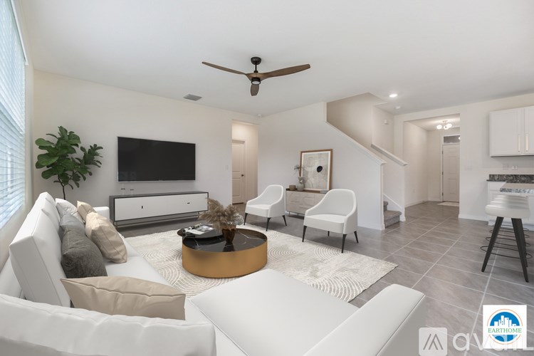 A living room with a white sofa, a coffee table, and a television.