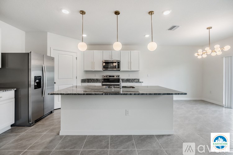 A kitchen with a marble countertop and stainless steel appliances.