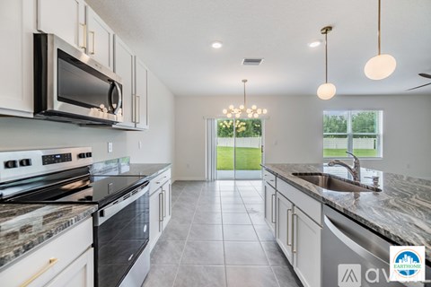 A kitchen with a black stove top oven and a black microwave.