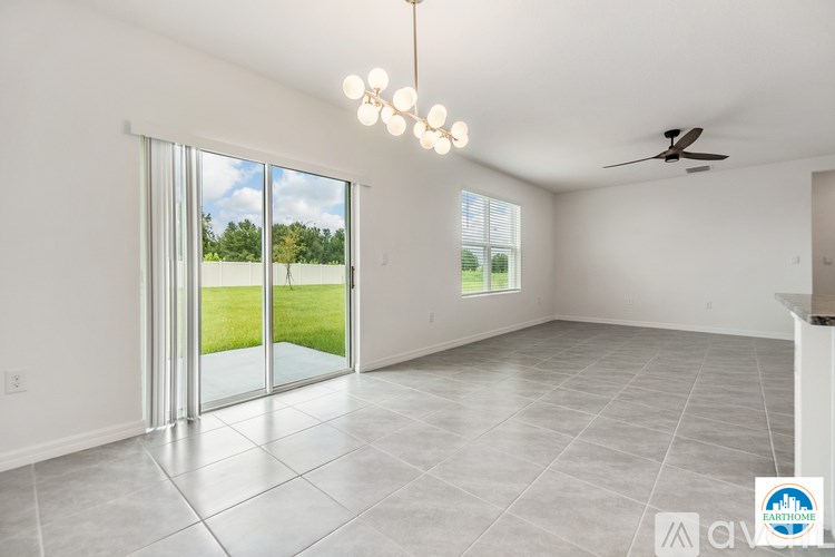 A spacious room with a sliding glass door leading to a green lawn.