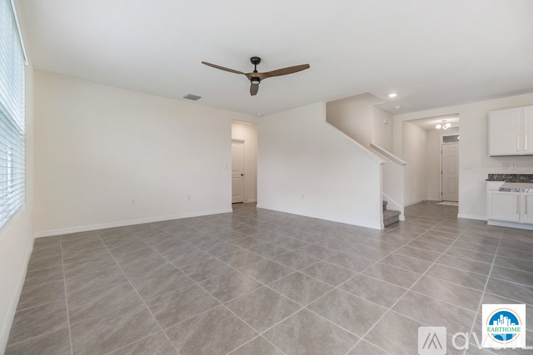 A spacious room with a ceiling fan and lighting fixtures.