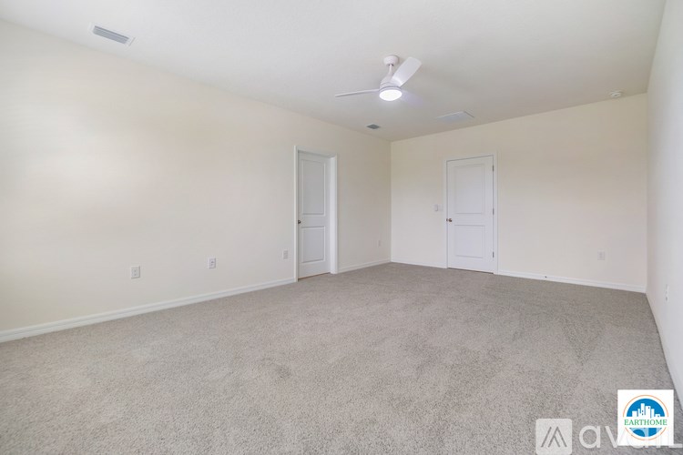 A spacious room with carpeted floor and white walls.
