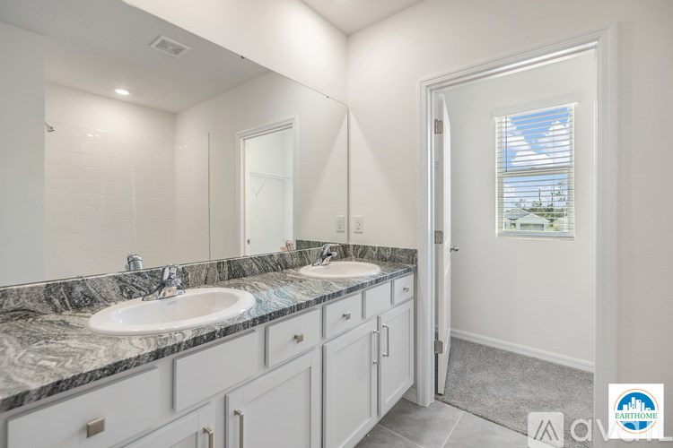 A bathroom with two sinks and a large mirror.