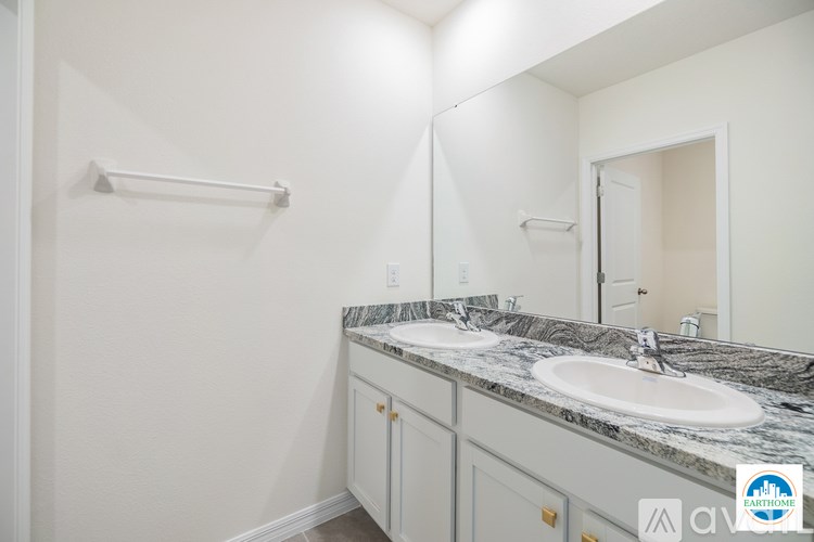 A bathroom with a marble counter top and a white sink.