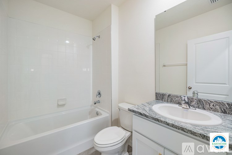 A white bathroom with a tub, toilet, and sink.