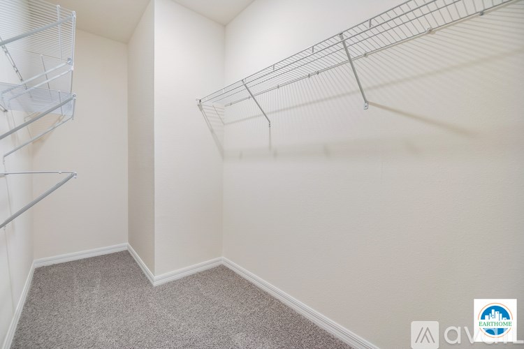 A bare room with a wire shelving unit on the wall.